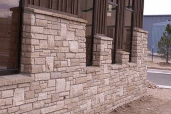Buff drystack veneer stone wall — natural ledgestone facing on a commercial building